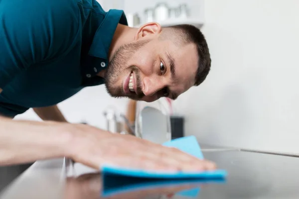 Uomo con straccio pulizia fornello a casa cucina — Foto Stock