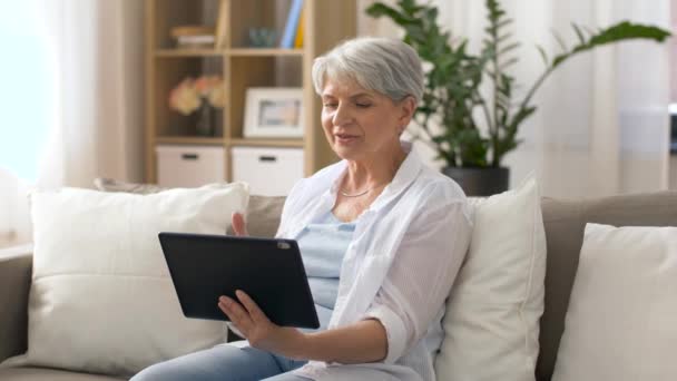 Mujer mayor que tiene chat de vídeo en la tableta de PC — Vídeos de Stock