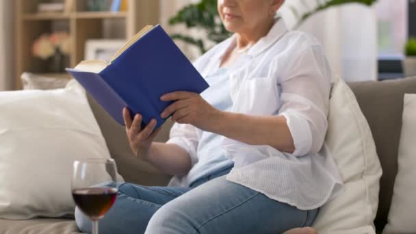 Oudere vrouw leest boek thuis — Stockvideo
