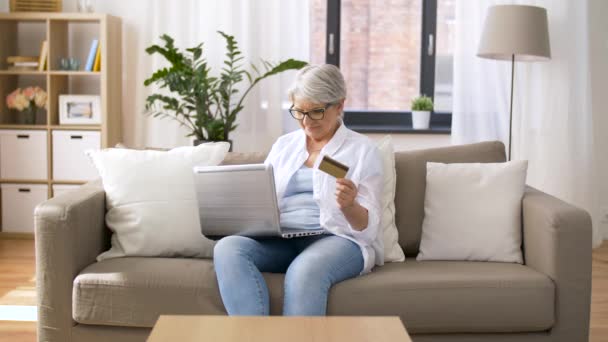 Oudere vrouw met laptop en creditcard thuis — Stockvideo