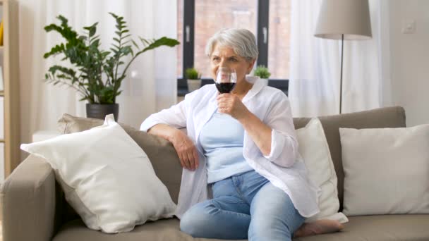 Seniorin trinkt zu Hause Rotwein aus Glas — Stockvideo