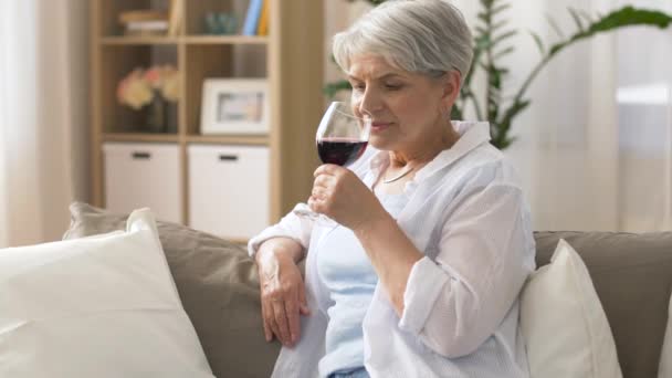 Senior vrouw rode wijn drinken uit glas thuis — Stockvideo