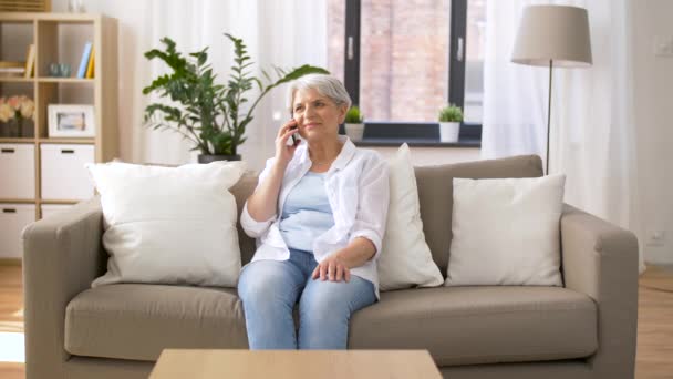 Mujer mayor llamando en el teléfono inteligente en casa — Vídeos de Stock