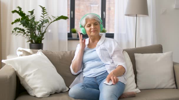 Mujer mayor en auriculares escuchando música — Vídeos de Stock