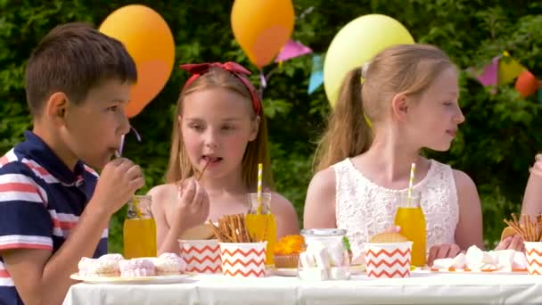 Gelukkige jonge geitjes op verjaardag partij op zomertuin — Stockvideo