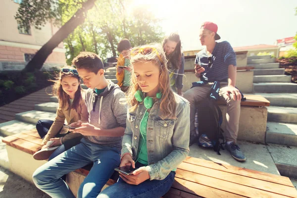 Grupp tonåriga vänner med smartphones utomhus — Stockfoto