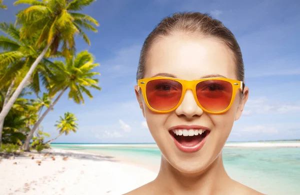 Femme heureuse ou adolescente en lunettes de soleil sur la plage — Photo