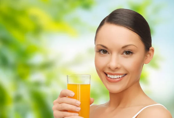 Mulher sorridente bebendo suco de laranja — Fotografia de Stock