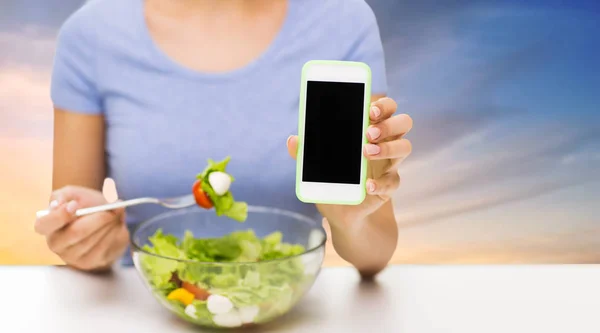 Close up of woman with smartphone eating salad — Stock Photo, Image