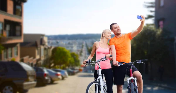 Para z rowerami robienie selfie przez smartfona — Zdjęcie stockowe