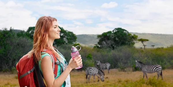 Glückliche Frau mit Rucksack über afrikanischer Savanne — Stockfoto