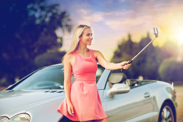 Женщина фотографирует с помощью селфи-палки в машине — стоковое фото