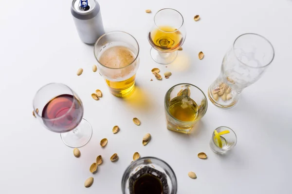 Bicchieri di bevande alcoliche diverse sul tavolo disordinato — Foto Stock