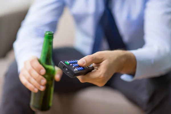 Az ember a tv távirányító, ivott sört közelről — Stock Fotó