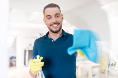 man in rubber gloves cleaning window with rag clipart