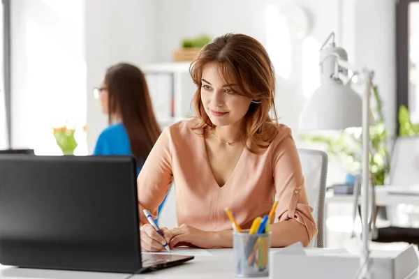 Empresária com laptop trabalhando no escritório — Fotografia de Stock