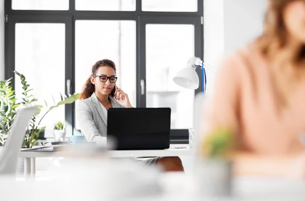 Empresária chamando no smartphone no escritório — Fotografia de Stock