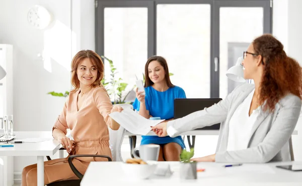 Mujeres de negocios que se dan papeles en la oficina —  Fotos de Stock