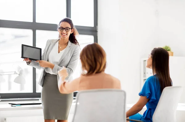 Женщина показывает планшетный ПК для бизнес-команды в офисе — стоковое фото
