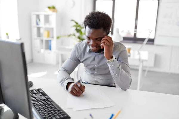 Hombre de negocios llamando en teléfono inteligente en la oficina — Foto de Stock