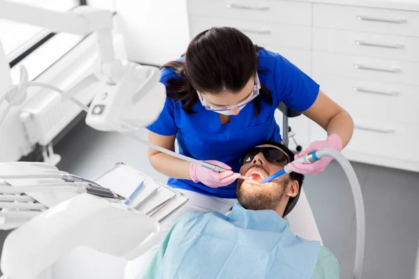 Dentista tratando os dentes dos pacientes na clínica odontológica — Fotografia de Stock