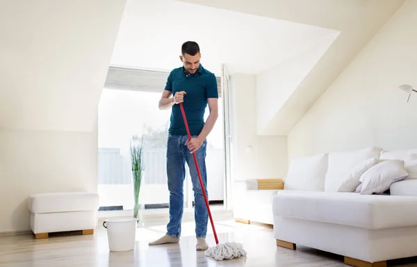 Homem com esfregão e balde chão de limpeza em casa — Fotografia de Stock