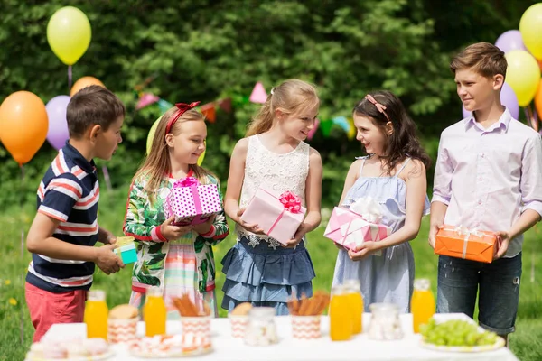 Niños felices con regalos en la fiesta de cumpleaños en verano —  Fotos de Stock
