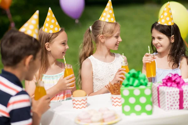 Glada barn på födelsedagsfest på sommarträdgård — Stockfoto