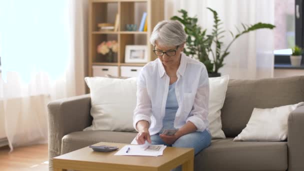 Senior femme avec de l'argent et des factures à la maison — Video