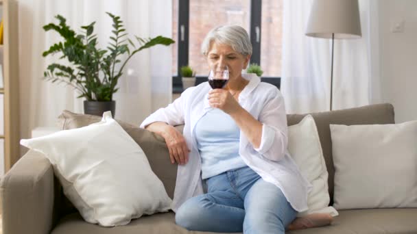 Senior vrouw rode wijn drinken uit glas thuis — Stockvideo
