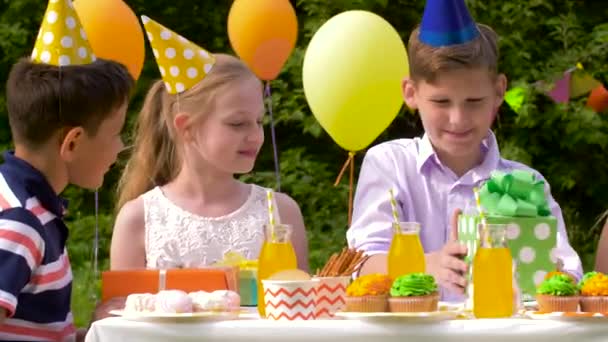 Niños dando regalos a niño de cumpleaños en la fiesta — Vídeo de stock