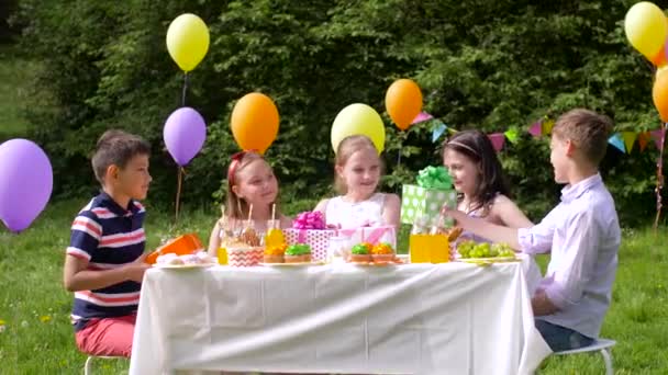 Niños dando regalos a niño de cumpleaños en la fiesta — Vídeos de Stock