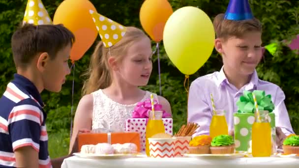 Дети дарят подарки имениннику на вечеринке — стоковое видео