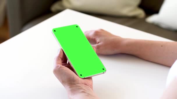 Hands holding smartphone with blank green screen — Stock Video