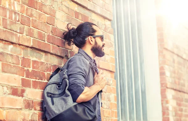 Homem com mochila em pé na parede de rua da cidade — Fotografia de Stock