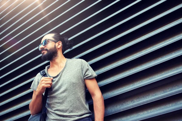 Hombre con mochila de pie en la ciudad pared de la calle —  Fotos de Stock