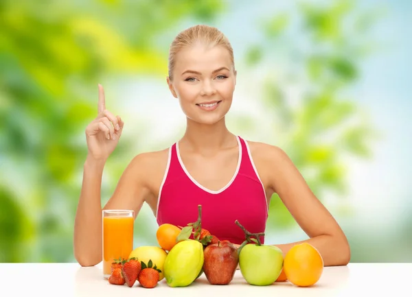 Mulher com frutas e suco sobre fundo verde — Fotografia de Stock