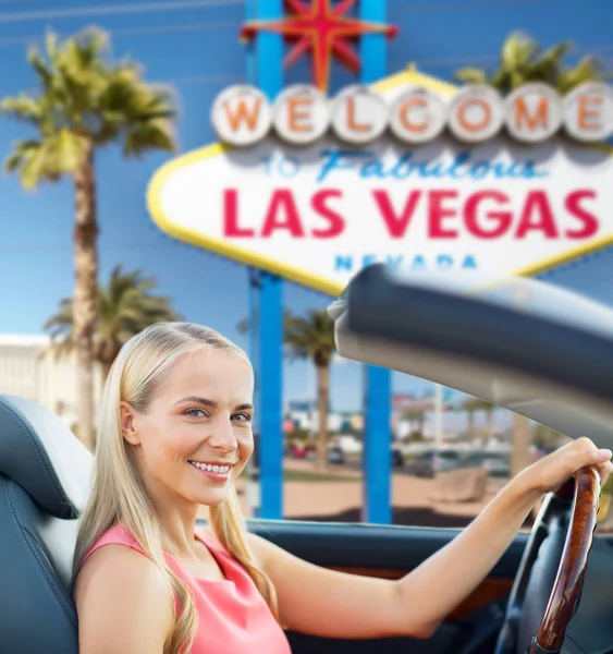 Mujer conduciendo coche descapotable sobre las vegas signo — Foto de Stock