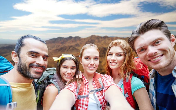 Amigos com mochila tomando selfie ove montanhas — Fotografia de Stock