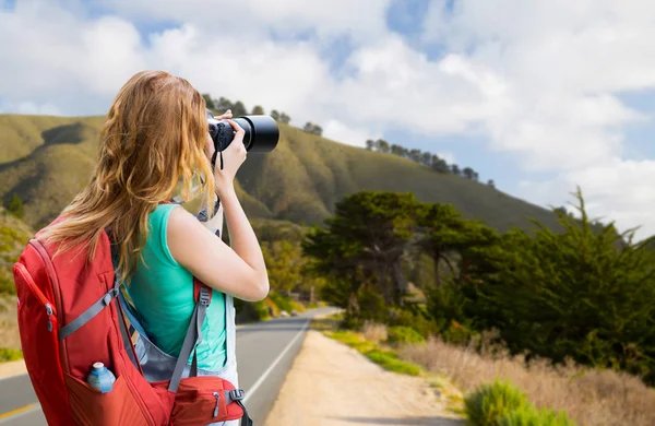 Žena s batohem a fotoaparát na big sur coast — Stock fotografie