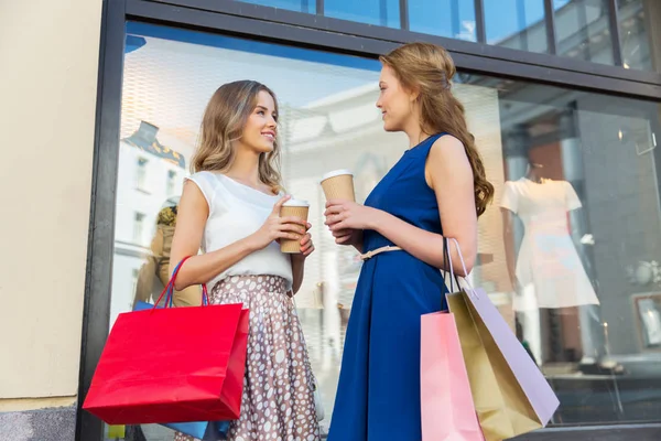 Glada kvinnor med shoppingkassar och kaffe utomhus — Stockfoto