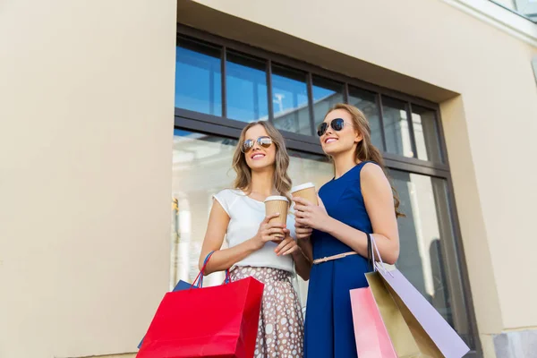 Glückliche Frauen mit Einkaufstaschen und Kaffee im Freien — Stockfoto