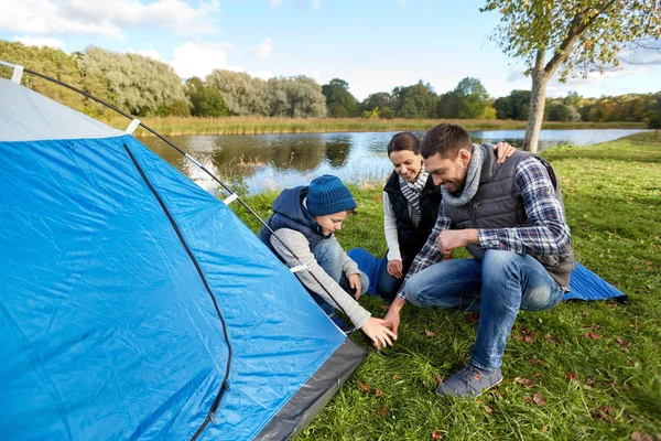 Pais felizes e filho montar tenda no parque de campismo — Fotografia de Stock