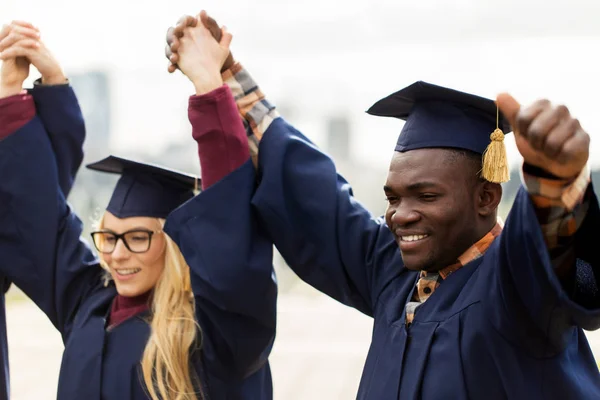 Glada studenter firar examen — Stockfoto