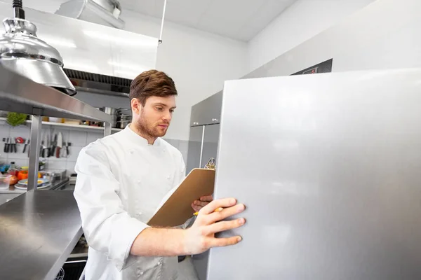 Chef com área de transferência fazendo inventário na cozinha — Fotografia de Stock