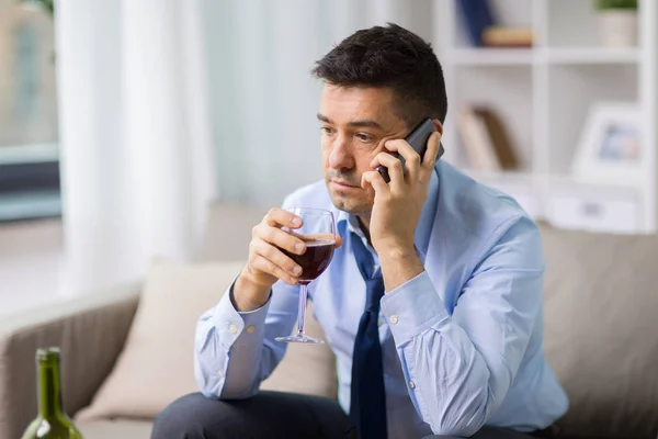 Drunk man with alcohol calling on smartphone — Stock Photo, Image