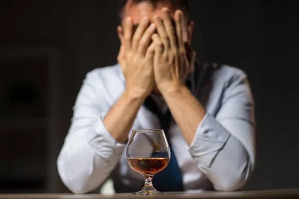 Berusad man med glas alkohol på bord på natten — Stockfoto