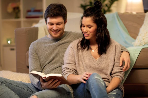 Feliz pareja leyendo libro en casa —  Fotos de Stock