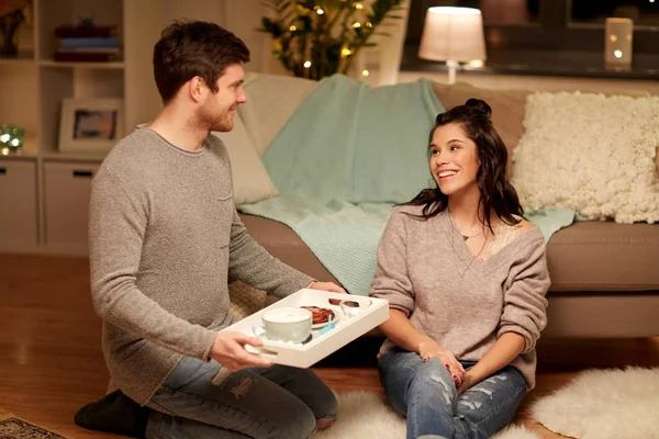 Feliz pareja con comida en la bandeja en casa — Foto de Stock