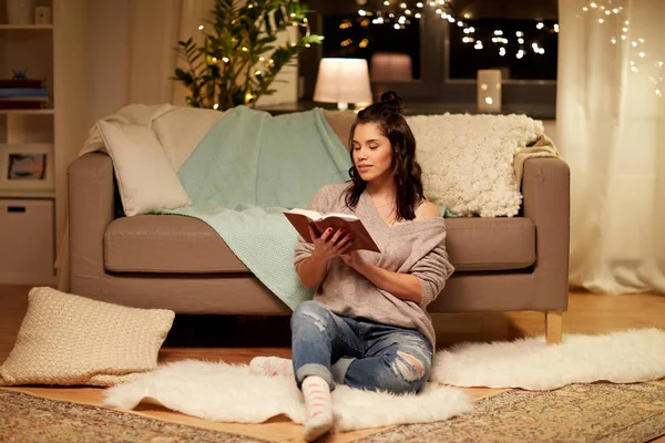 Heureuse jeune femme lecture livre à la maison — Photo